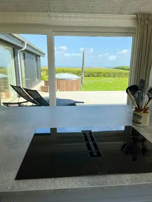 a kitchen counter with a view of a yard through a window at Summer House With Wilderness Bath And Water Views in Vinderup