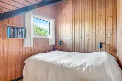 a bedroom with a bed and a window at Lovely Holiday Home With Wood-Burning Stove, Close To The North Sea In Klitmøller in Thisted