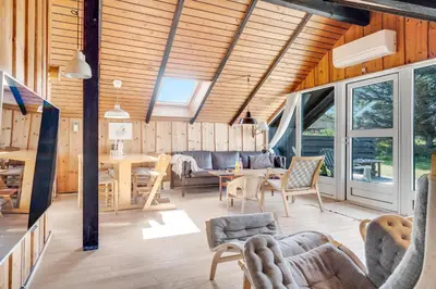 a living room with a table and chairs at Lovely Holiday Home With Wood-Burning Stove, Close To The North Sea In Klitmøller in Thisted