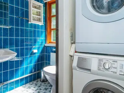 a blue tiled bathroom with a washing machine at 6 person holiday home in Højslev-By Traum in Højslev