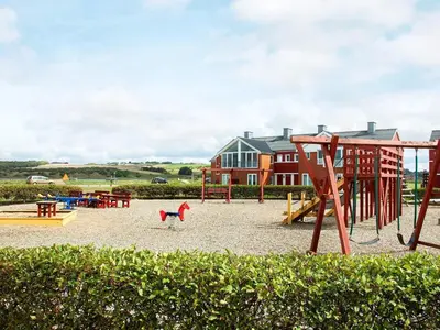 a playground with a slide and a swing set at 4-person cabin in Lemvig holiday park in Lemvig