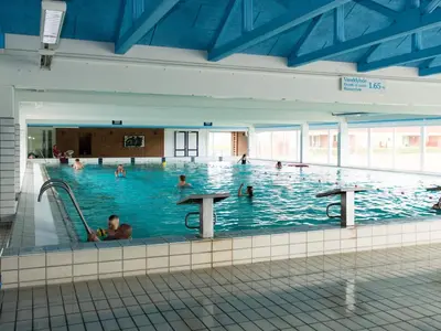 a large indoor swimming pool with people in it at 4-person cabin in Lemvig holiday park in Lemvig