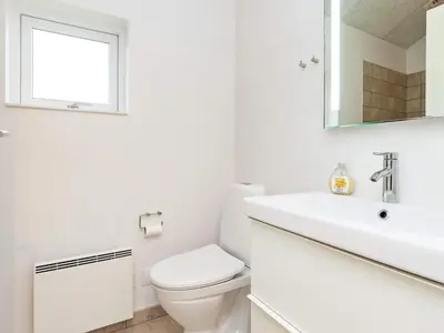 a white bathroom with a toilet and a sink at 8 person holiday home in Brovst-By Traum in Brovst