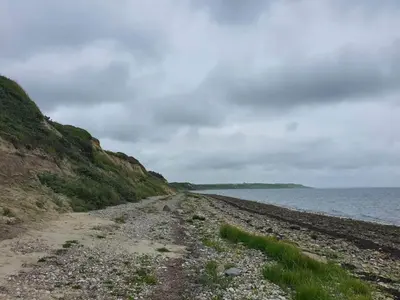 a rocky beach next to the ocean on a cloudy day at 12 person holiday home in Vestervig-By Traum in Vestervig