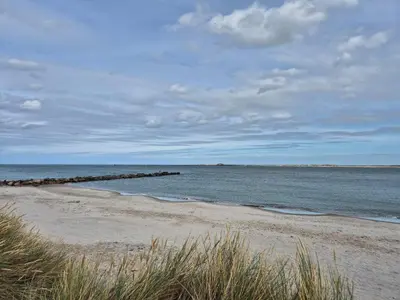 a sandy beach with a pier in the ocean at 8 person holiday home in Harboøre-By Traum in Harboør