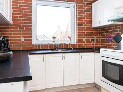 a kitchen with white cabinets and a brick wall at 8 person holiday home in Harboøre-By Traum in Harboør