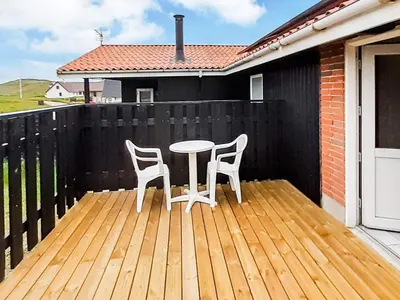 a patio with two chairs and a table on a wooden deck at 8 person holiday home in Harboøre-By Traum in Harboør