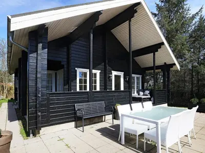 a small black house with a table and chairs at 7 person holiday home in Løgstør-By Traum in Løgstør