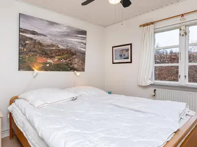 a bed in a bedroom with a painting on the wall at 6 person holiday home in Thyholm-By Traum in Thyholm