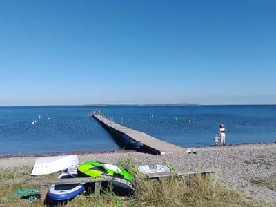 a beach with a pier and boats on the beach at 6 person holiday home in Thyholm-By Traum in Thyholm