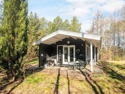 a black house with a porch and a patio at 5 person holiday home in Højslev-By Traum in Højslev
