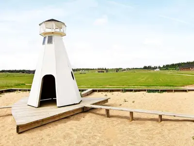 a lighthouse sitting on the sand on a beach at 16 person holiday home in Brovst-By Traum in Brovst