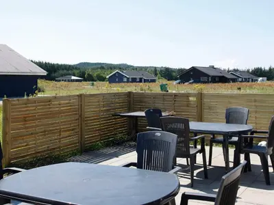 a patio with tables and chairs and a fence at 16 person holiday home in Brovst-By Traum in Brovst
