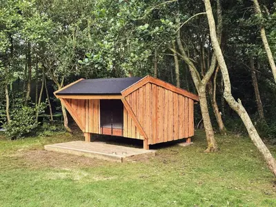 a small house with a black roof in the grass at 7 person holiday home in Hurup Thy-By Traum in Sønder Ydby