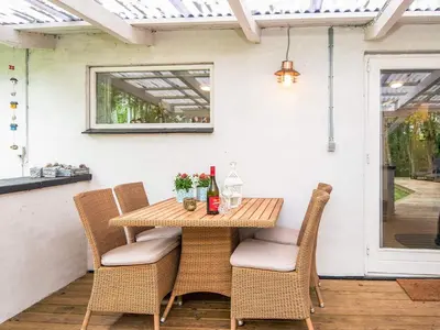 a wooden table and chairs on a patio at 7 person holiday home in Hurup Thy-By Traum in Sønder Ydby