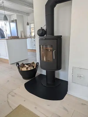 a black stove in a room with a kitchen at Strandhuset in Agger