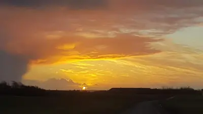 a sunset with the sun setting in the horizon at Strandhuset in Agger