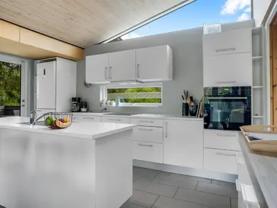 a white kitchen with white cabinets and a window at Holiday Home Ginne - 1km to the fjord by Interhome in Løgstør