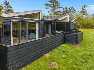 a home with a black house with a yard at Holiday Home Ginne - 1km to the fjord by Interhome in Løgstør