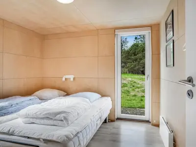 a bed in a room with a large window at Holiday Home Ginne - 1km to the fjord by Interhome in Løgstør