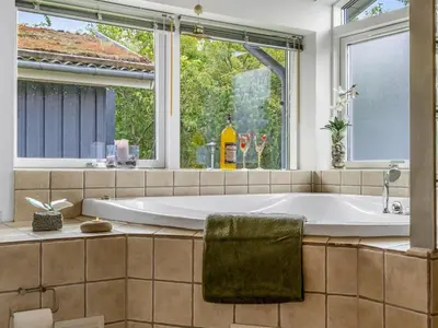 a bath tub in a bathroom with a window at Holiday Home Selvi - 2-2km from the sea by Interhome in Blokhus