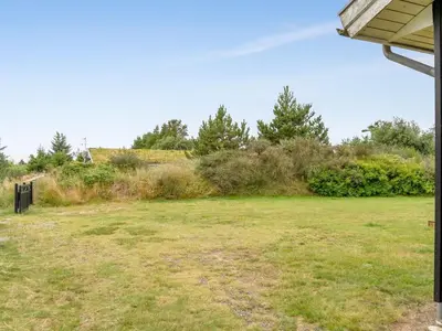 a field of grass with trees in the background at Holiday Home Selvi - 2-2km from the sea by Interhome in Blokhus