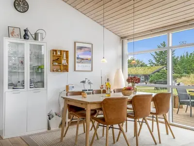 a dining room with a wooden table and chairs at Holiday Home Selvi - 2-2km from the sea by Interhome in Blokhus