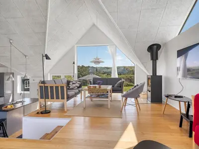 a living room with a couch and a table at Holiday Home Tekla - 180m from the sea by Interhome in Blokhus