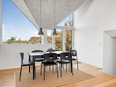 a dining room with a table and black chairs at Holiday Home Tekla - 180m from the sea by Interhome in Blokhus