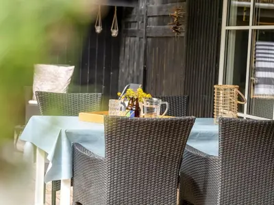 an outdoor table with chairs and a blue table cloth at Holiday Home Nahuel - 1km from the sea by Interhome in Blokhus