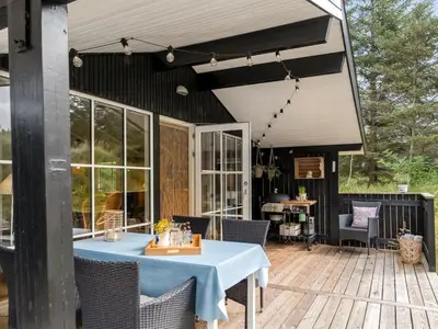 a patio with a table and chairs on a deck at Holiday Home Nahuel - 1km from the sea by Interhome in Blokhus
