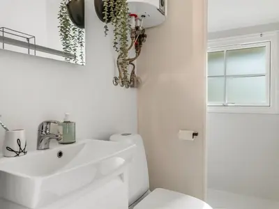a white bathroom with a sink and a toilet at Holiday Home Nahuel - 1km from the sea by Interhome in Blokhus