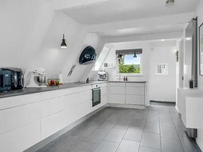 a white kitchen with white cabinets and a window at Holiday Home Ernstine by Interhome in Farsø