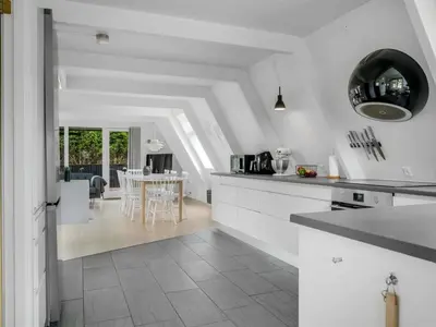 a kitchen with white cabinets and a dining room at Holiday Home Ernstine by Interhome in Farsø