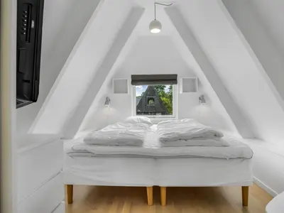 a bed in a white room with a window at Holiday Home Ernstine by Interhome in Farsø