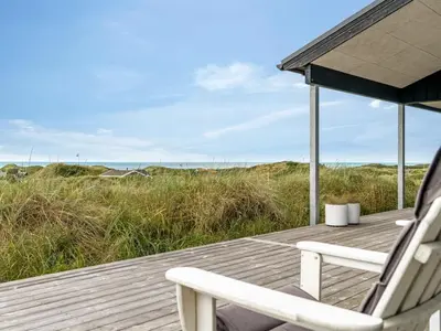a couple of chairs sitting on a wooden deck at Holiday Home Jannus - 600m from the sea by Interhome in Saltum
