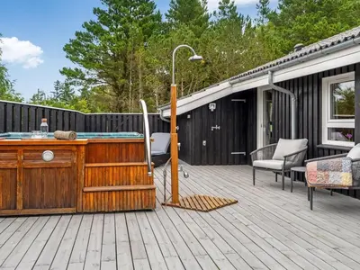 a wooden deck with a hot tub on a house at Holiday Home Eeske - 2-5km from the sea by Interhome in Blokhus