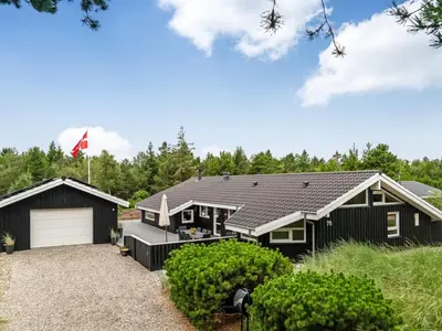 a black house with a white garage at Holiday Home Eeske - 2-5km from the sea by Interhome in Blokhus