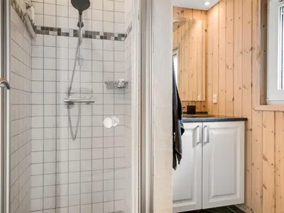 a bathroom with a shower with white tiles at Holiday Home Eeske - 2-5km from the sea by Interhome in Blokhus