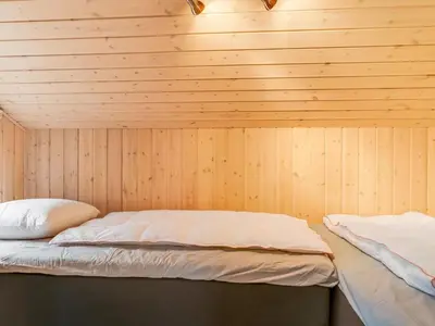 a room with two beds in a wooden wall at Holiday Home Eeske - 2-5km from the sea by Interhome in Blokhus