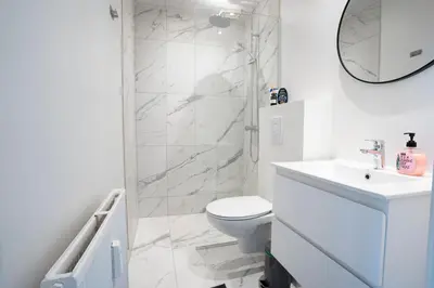 a white bathroom with a toilet and a shower at Modernized Bed & Bath in Holstebro