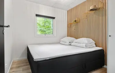 a small bedroom with a bed with a window at Amazing Home In Aars With Wifi in Års