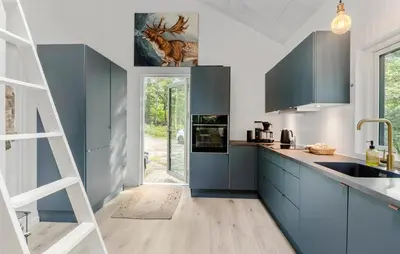 a kitchen with blue cabinets and a ladder at Amazing Home In Aars With Wifi in Års
