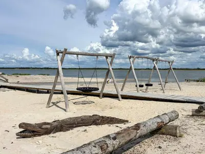 two swings on a beach with the ocean in the background at 10 person holiday home in Vinderup-By Traum in Vinderup