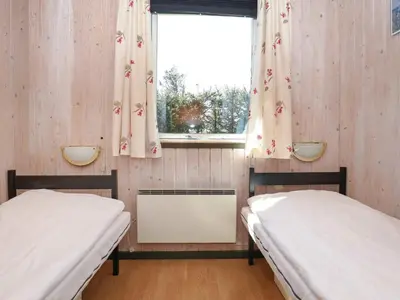 two beds in a small room with a window at 6 person holiday home in Løkken-By Traum in Løkken
