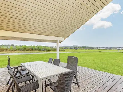 a wooden deck with a table and chairs on it at 10 person holiday home in Brovst-By Traum in Brovst
