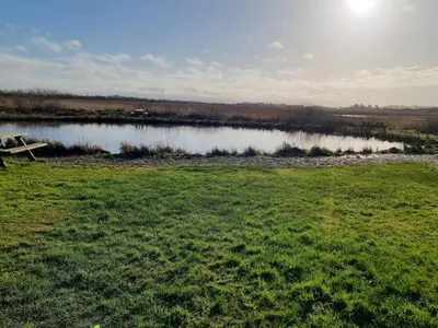 a picnic table in a field next to a lake at 4 person holiday home in Bøvlingbjerg in Bøvlingbjerg