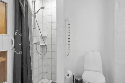 a white bathroom with a toilet and a shower at 288-Harboore-Doblervej-15 in Harboør