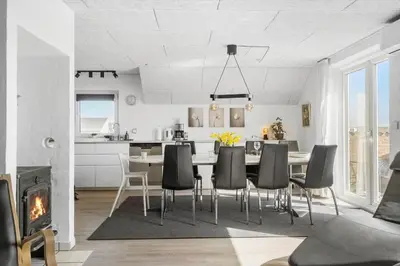 a kitchen and dining room with a table and chairs at 288-Harboore-Doblervej-15 in Harboør