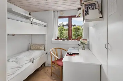 a small white room with a bed and a desk at G295-Lemvig-Syrenvej-95 in Lemvig